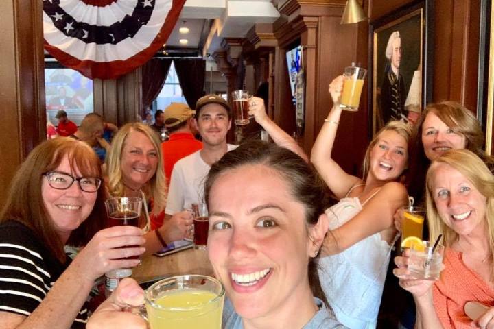 a group of people are drinking from a wine glass posing for the camera